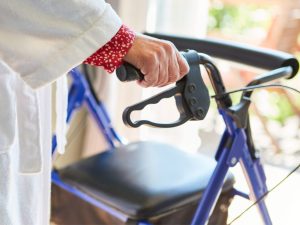 Close-up of a suspension rollator with two wheels, designed for enhanced mobility and comfort. The rollator features adjustable handles and a sturdy frame for better support