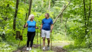 Image of a beautiful park and two people walking with walking sticks and canes. They are both happy and smiling, enjoying the freedom and independence of using mobility aids.