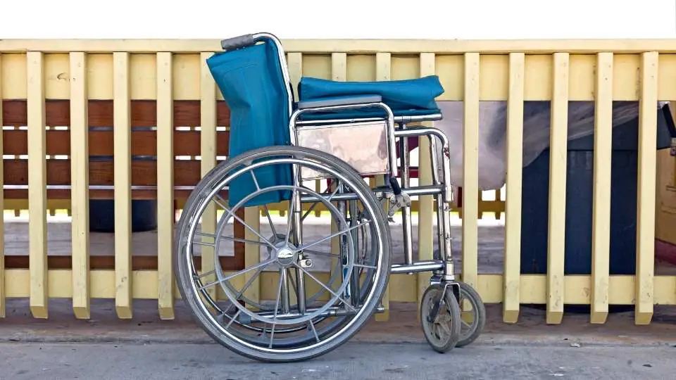 Folded wheelchair placed on the side to demonstrate the space-saving design.