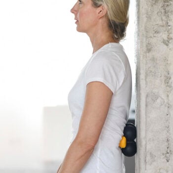 Side view of woman using the Sissel Spinefitter Trigger Tool with the Extension Kit