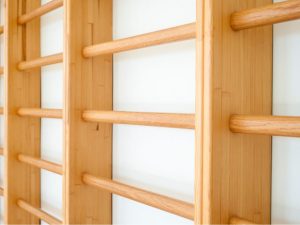 Close-up view of wooden wall bars used in physical therapy for enhancing strength, mobility, and rehabilitation exercises.