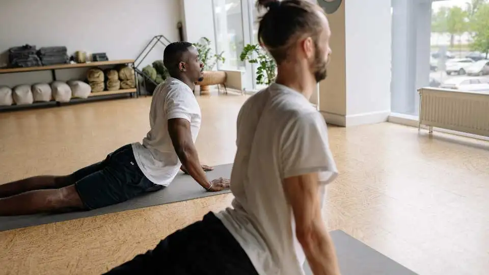 Males practices yoga using a yoga mat with 6mm thickness for additional back support.