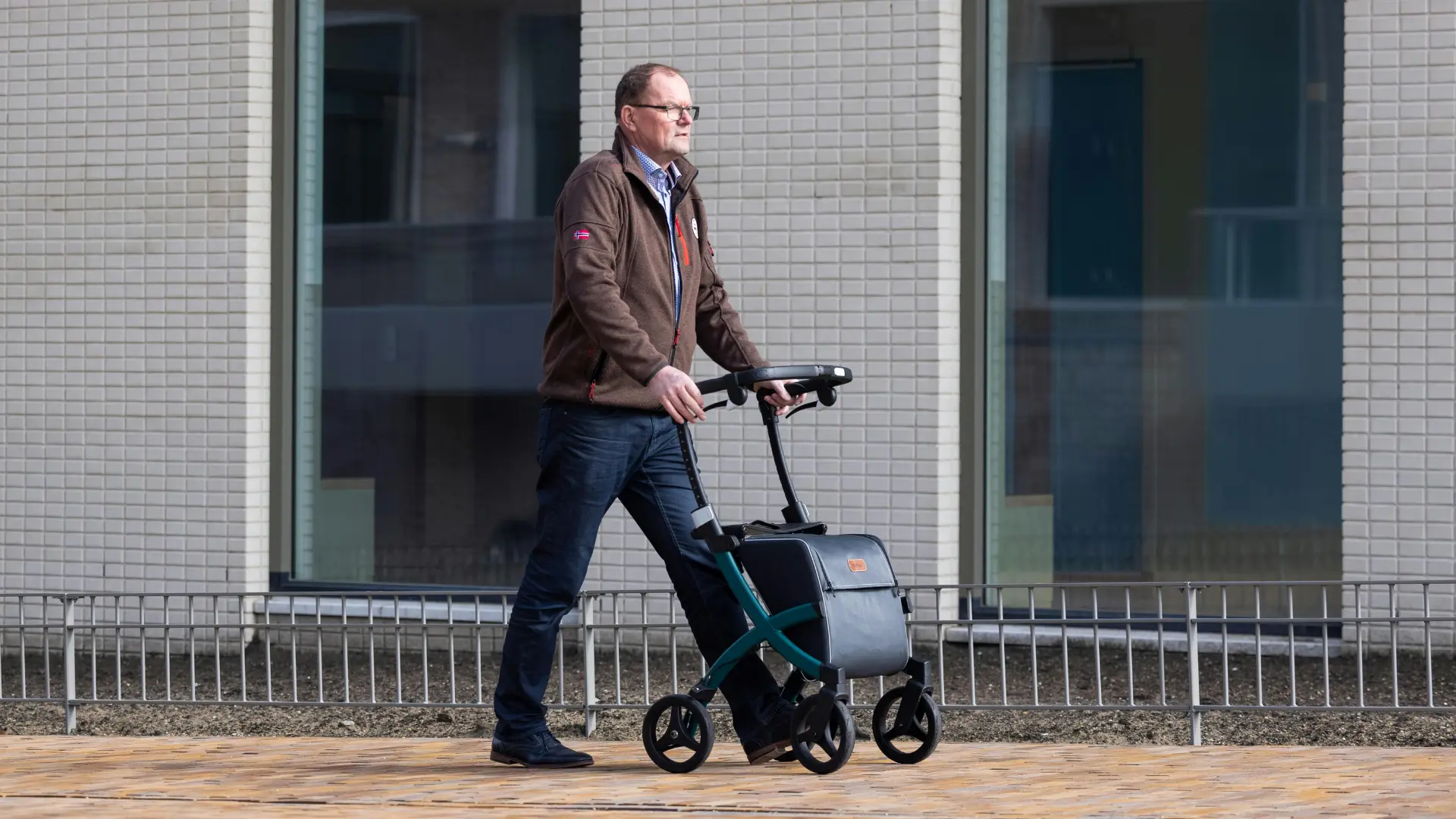 A senior using a rollator walker outdoors for shopping.