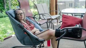 Elderly woman post ankle surgery wears an orthopaedic boot.