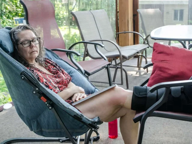 Elderly woman post ankle surgery wears an orthopaedic boot.