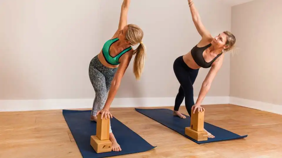 Females demonstrating how to use yoga blocks during workout.
