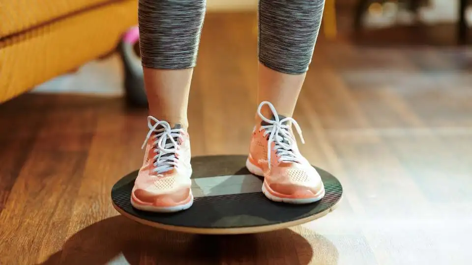 A person using wobble board to strengthen knee ligaments after an injury.