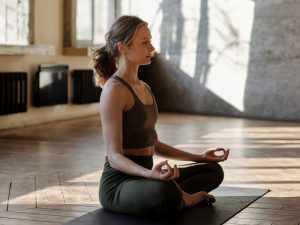 A woman practicing upward-facing dog pose in bright indoor light, illustrating how yoga enhances performance and prevents common sports injuries