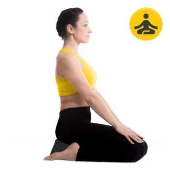 A woman sits in a seiza kneeling meditation pose on a cushion, wearing a yellow top and black leggings. Her hands rest on her thighs, and a yellow icon showing a meditative figure appears in the top right corner.