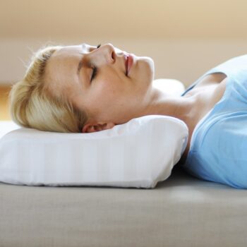 Woman lying comfortably on her side using the SISSEL Soft Deluxe Orthopaedic Pillow for neck support