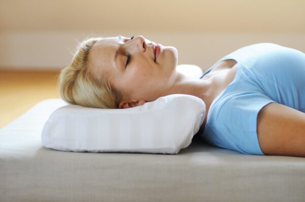 Woman lying comfortably on her side using the SISSEL Soft Deluxe Orthopaedic Pillow for neck support