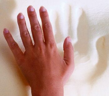 Hand gently pressing down on the soft, supportive surface of the SISSEL Soft Deluxe Orthopaedic Pillow