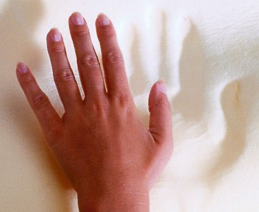 Hand gently pressing down on the soft, supportive surface of the SISSEL Soft Deluxe Orthopaedic Pillow