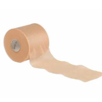 A single roll of tan-coloured pre-wrap foam tape partially unrolled, showing its thin, soft texture for use under adhesive bandages